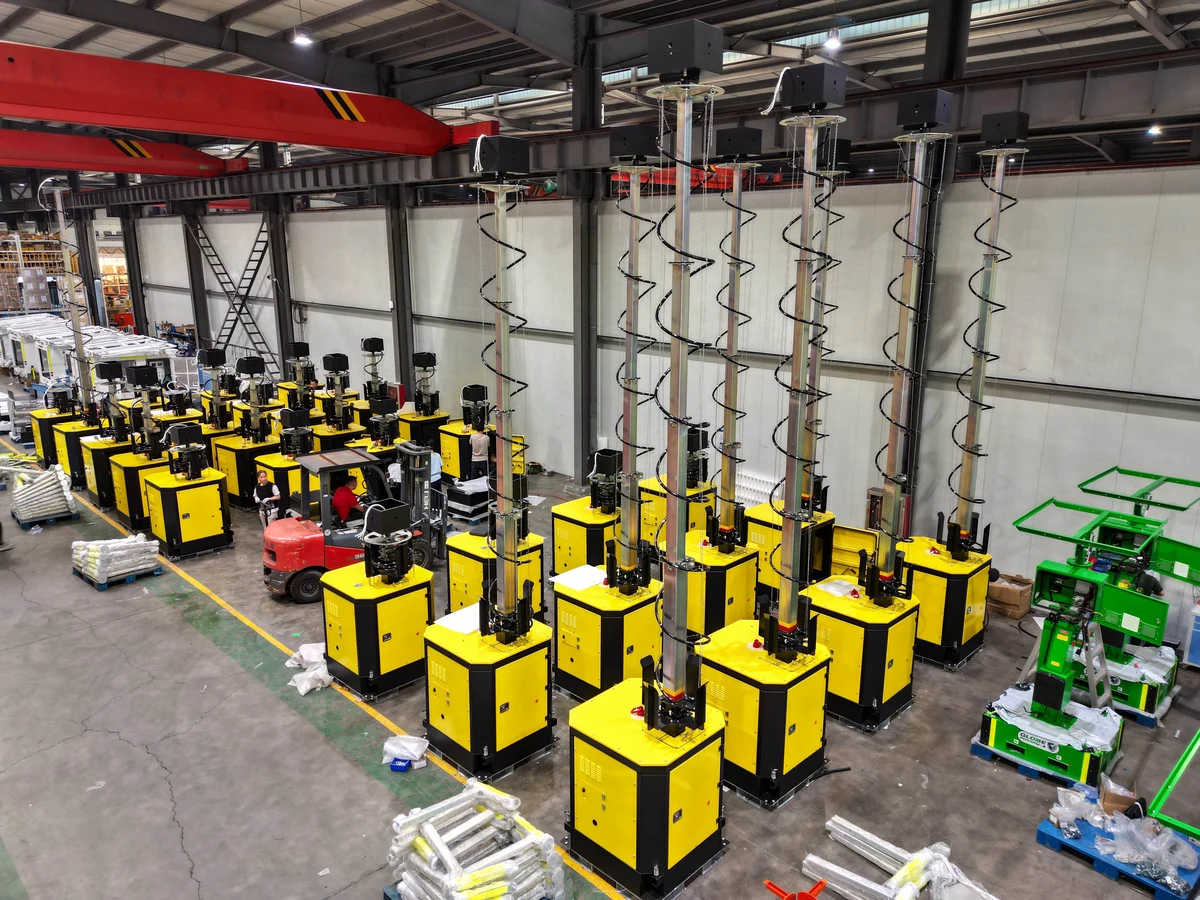 Supplied workshop photograph showing rows of yellow mast equipment